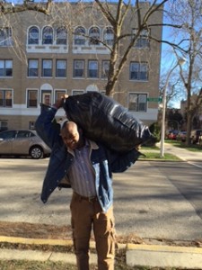 Secretary Abdulatif Isaac in Chicago on Dec., 19, 2015, carrying clothing to newly arrived Darfuri families.